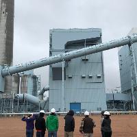 WAFERx team members taking in the scale of the Dry Folk Station, where flue gas will be diverted and used to study CCUS technologies.
