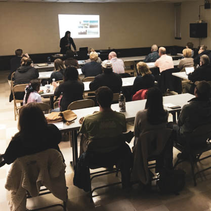 Photo of Kelli Roemer presenting to a group of people at a meeting in Beulah, ND